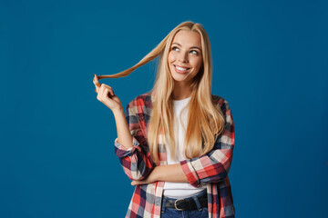 Blonde young happy woman smiling and playing with her hair