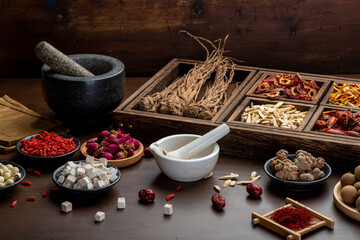 Ancient Chinese medicine books and herbs on the table