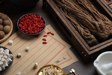Ancient Chinese medicine books and herbs on the table