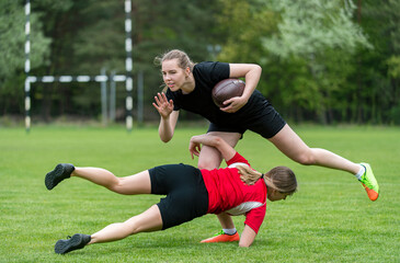 Girls playing rugby together outside in summer. Woman sport concept