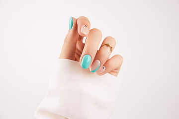 Womans hand with trendy turquoise manicure with copy space