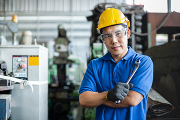 portrait image asian engineer men wearing uniform safety and holding wrench tool in factory.  male...