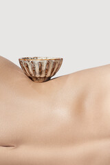 Cropped shot of traditional tea bowl on graceful female body. The beige ceramic bowl with glazed...