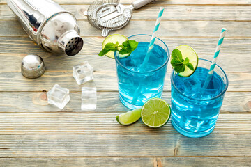 Blue beverage, iced alcohol cocktail drink with lime and mint