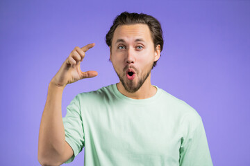 Young man showing invisible abstract big subject or object. Large concept.