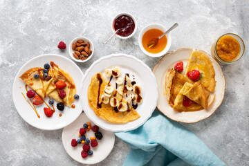 Overhead view of  plate with breakfast crepes and berries, three plates