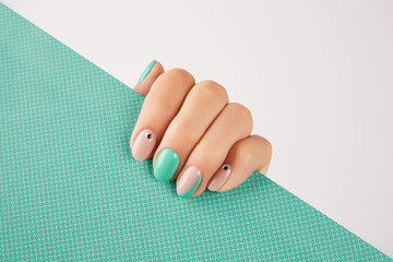 Womans hand with trendy turquoise manicure with copy space