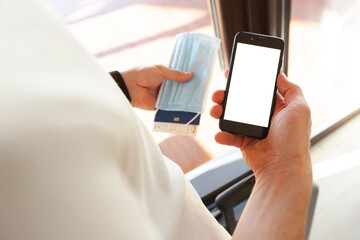 The man holding the mobile phone with blank screen as a mockup for digital vaccination certificate