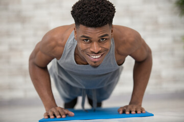 Obraz premium muscular mixed race man in plank position