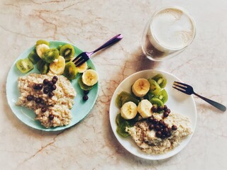 Lifestyle and food casual photography. Composition with coffee and oatmeal with fruits on the kitchen table.