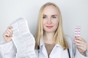The doctor on a white background reads the instructions for medicines. The specialist looks at the...