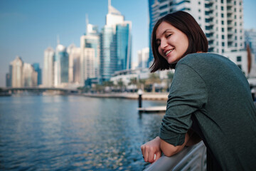 Fototapeta na wymiar Happy young female traveler in the big city of Dubai, UAE