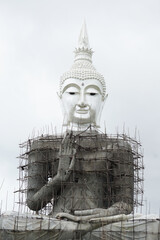 Unfinished big buddha statue with white sky background