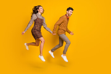 Fototapeta na wymiar Full body profile side photo of man and woman look go jump empty space smile isolated on yellow color background