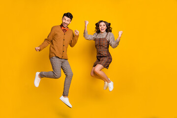 Fototapeta na wymiar Full body photo of brunette crazy man and woman jump happy winner isolated on yellow color background