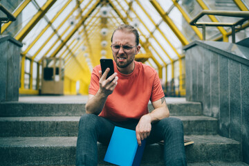 Man looking in disgust at smartphone screen