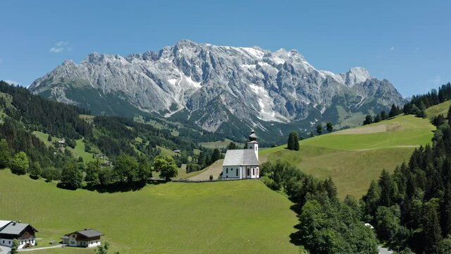 Parish church of Dienten with Hochk&ouml;nig mountain on the background. Pinzgau, Salzburg, Austria. Aerial view.
