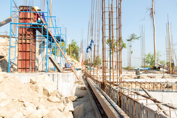 Rusted round bars are tied to the wire as the base of beams and columns in the construction site. Concept of construction in mountain