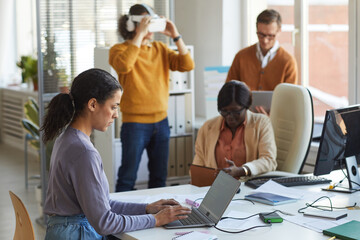Ethnic Young Woman Using Laptop in IT Office