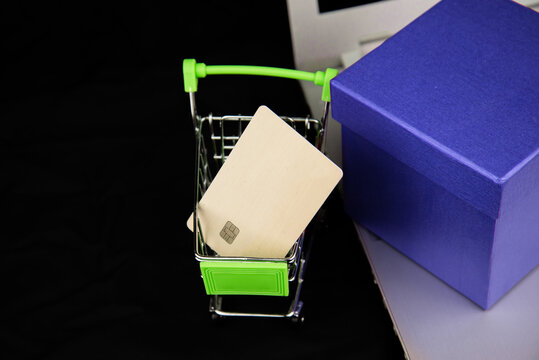 Group object Calendar 2021 and credit card in the shopping cart and blue gitf box on laptop with dark background. Business Shopping concept. e-commerce or online shopping concept. new year gift.