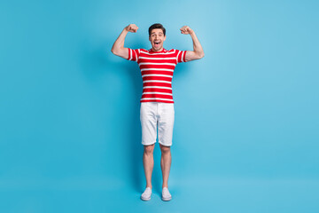 Full length body size photo of guy cheerful showing strong hands muscles isolated on bright blue color background