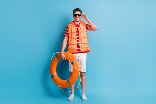 Full Length Body Photo Man Wearing Life Vest Sunglass Ready To Swim In The Sea Isolated On Vibrant Blue Color Background