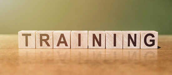 TRAINING word written on wooden blocks on wooden table. Concept for your design.