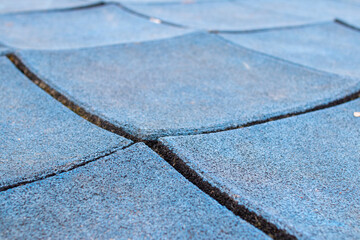broken rubber tiles in the playground, old Poured-in-Place, PIP, tartan surface, tartan track, warped, damaged, worn out
