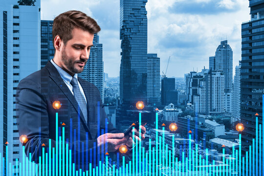 Handsome Caucasian analyst researches daily analytics using phone to find the financial solution for venture capital project. Hologram chart over Bangkok city background