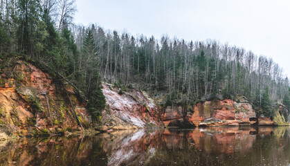 Springu (Spriņģu) cliffs by the Gauja river in the Gauja National park. Sandstone rock by a river in Latvia