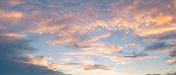 Beautiful sky painted by the sun leaving bright golden shades.Dense clouds in twilight sky in winter evening.Image of cloud sky on evening time.Evening sky scene with golden light from the setting sun
