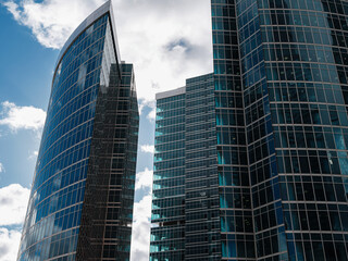 Modern corporate buildings against blue cloud sky.