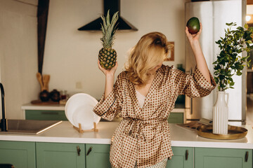 Beautiful attractive woman in the morning in the kitchen in silk pajamas. romantic breakfast. Soft...