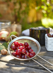 Fresh washed cherries on a sieve. Composition on the table