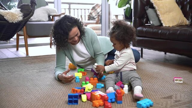 African american mother and child playing colorful building blocks