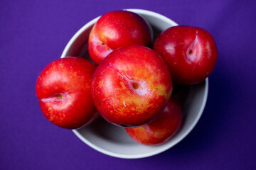 red plums on purple background