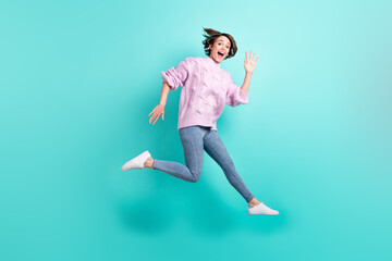 Fototapeta na wymiar Full length photo of shiny excited young lady dressed purple pullover jumping waving arm isolated teal color background