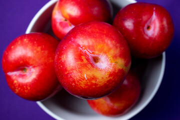 red plums on purple background