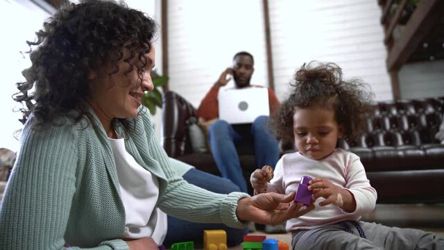 African american mother and daughter with cookie and building block at home