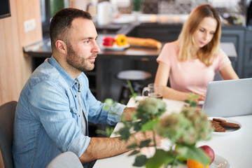 Beautiful young couple sitting at the table at home