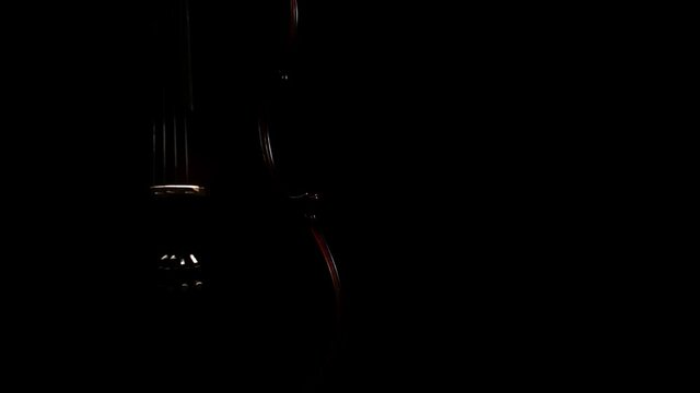 Violin spins slowly in the studio in darkness. Close-up of a violin. Symphony orchestra instrument. Stringed musical instrument on a black background.