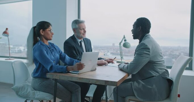 Multi-ethnic couple of hiring managers discussing future job opportunities with potential candidate adult employee