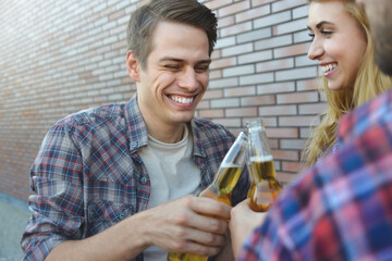 Group of young friends having fun with beer at street.