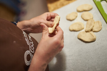 Obraz premium the cook kneads the dough in his hands