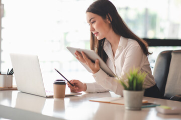 Portrait of Asian young woman working on laptop in her office