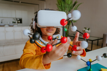 Girl using VR glasses holding molecular model