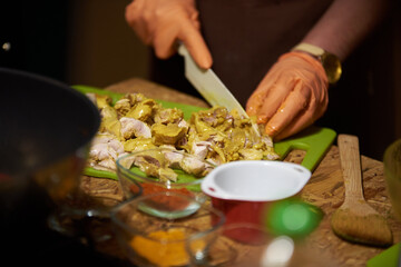 Cooking in the kitchen. cutting meat, wearing gloves