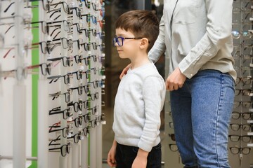 Mother with cute son. Family buy glasses