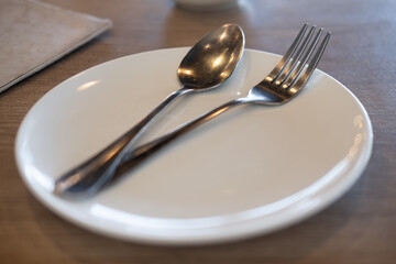 Silver cutlery on white dish
