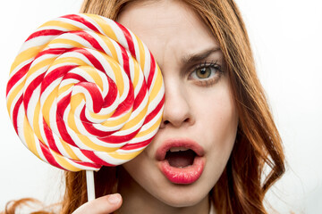 woman with big multicolored round face lollipop sweet candy close-up